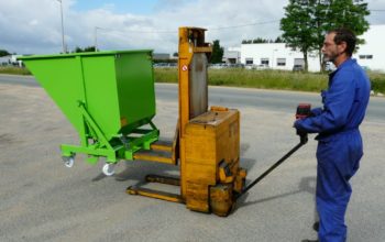 Gerbeur industriel avec benne basculante verte et ouvrier