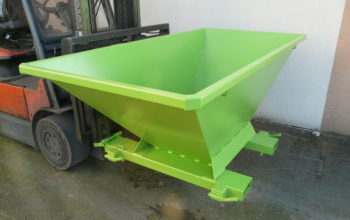 The image shows a bright green self-tipping skip (or hopper/benne basculante) attached to a forklift. The file name "tbl-prise-fourches-3.jpg" suggests "prise fourches" which means "forklift attachment" or "fork pockets". "tbl" could mean "table" but in this context "benne" or "basculante" (tipping) is more likely. Considering the image content and the filename cues, a good alt text would describe the object and its primary function. The object is a "benne basculante" (tipping skip/hopper) designed to be handled by a "chariot élévateur" (forklift). Let's try some options, keeping it under 10 words and optimized for SEO in French: 1. Benne basculante verte pour chariot élévateur à prise fourches. (9 words) - Good, descriptive. 2. Benne auto-basculante verte fixée sur chariot élévateur. (8 words) - Also good. 3. Benne basculante chariot élévateur verte, avec prise fourches. (8 words) - Good. I'll go with the one that is most direct and covers the key elements: "Benne basculante verte pour chariot élévateur à prise fourches."