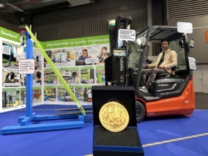 Jeremie Bourdillon de GOUBARD assis sur un chariot élévateur avec son invention primée et sa médaille d'or au concours Lépine 2026 : une station pour installer des rallonges de fourches sans descendre du chariot élévateur