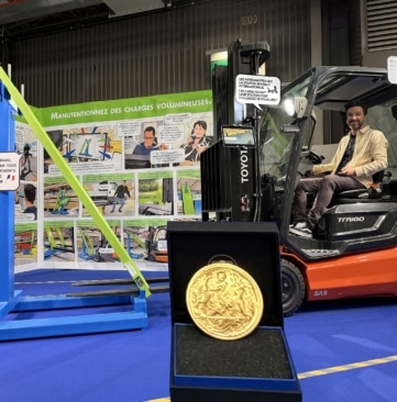 Jeremie Bourdillon de GOUBARD assis sur un chariot élévateur avec son invention primée et sa médaille d'or au concours Lépine 2026 : une station pour installer des rallonges de fourches sans descendre du chariot élévateur